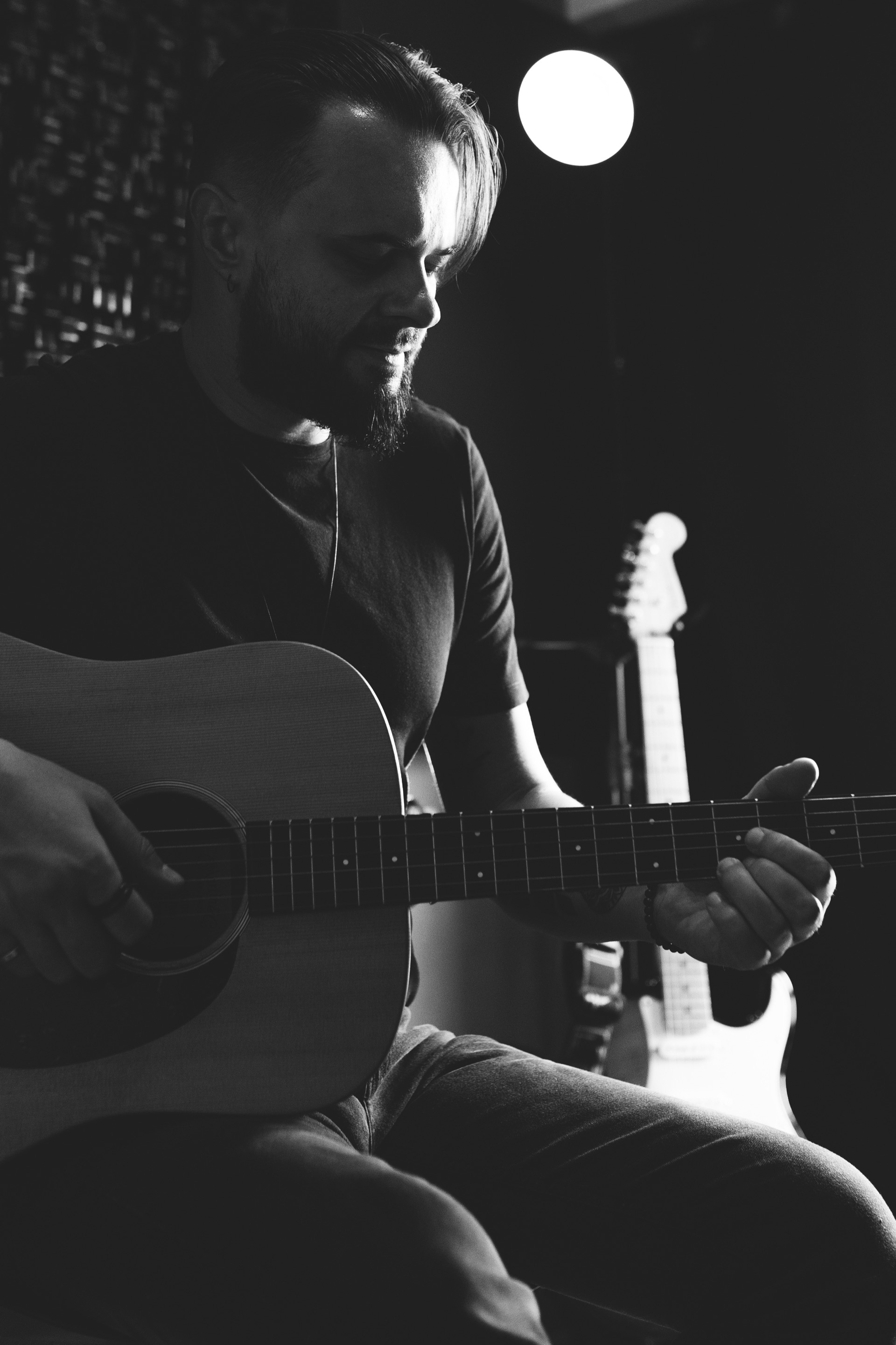 Thiago Melo ao violão no estúdio, em preto e branco